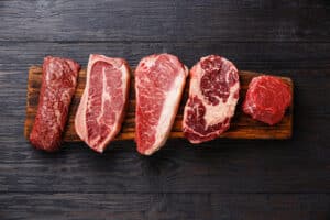 various cuts of steak on a cutting board that are available at Galla Park Steak in Columbus Ohio